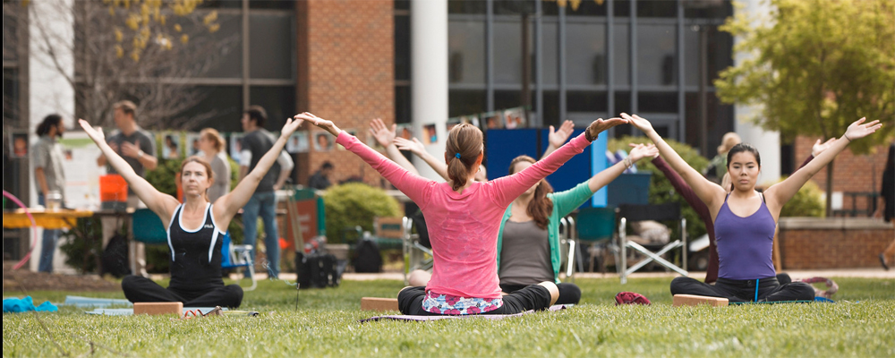 wellbeing slide no symbol group doing yoga in front of the library