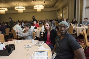 a white woman and a black man sitting at a table at the Leading to Well-Being conference