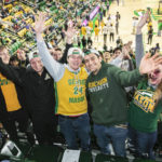 students in green and gold at a basketball game