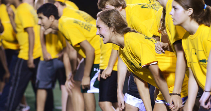 a groups of students in yellow shirts lining up as if for a race