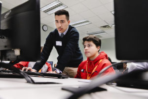 Mason junior Carlos Alvarez-Ayion helps Matias Nicholls of the Early Identification Program during a cybersecurity class at STEM Fusion. Photo by Lathan Goumas/Office of Communications and Marketing Photo Taken:Saturday, February 29, 2020
