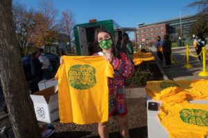Student volunteers hand out t-shirts at the annual Gold Rush event on the Fairfax Campus