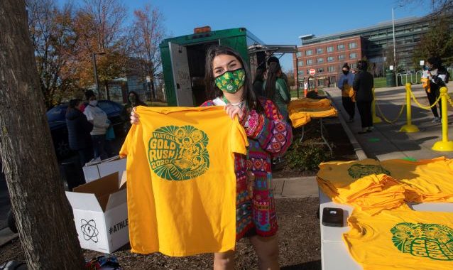 Student volunteers hand out t-shirts at the annual Gold Rush event on the Fairfax Campus