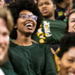 young black woman laughing in a crowd