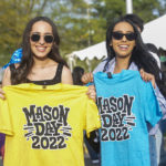 Students holding mason day tshirts at Mason day 2022