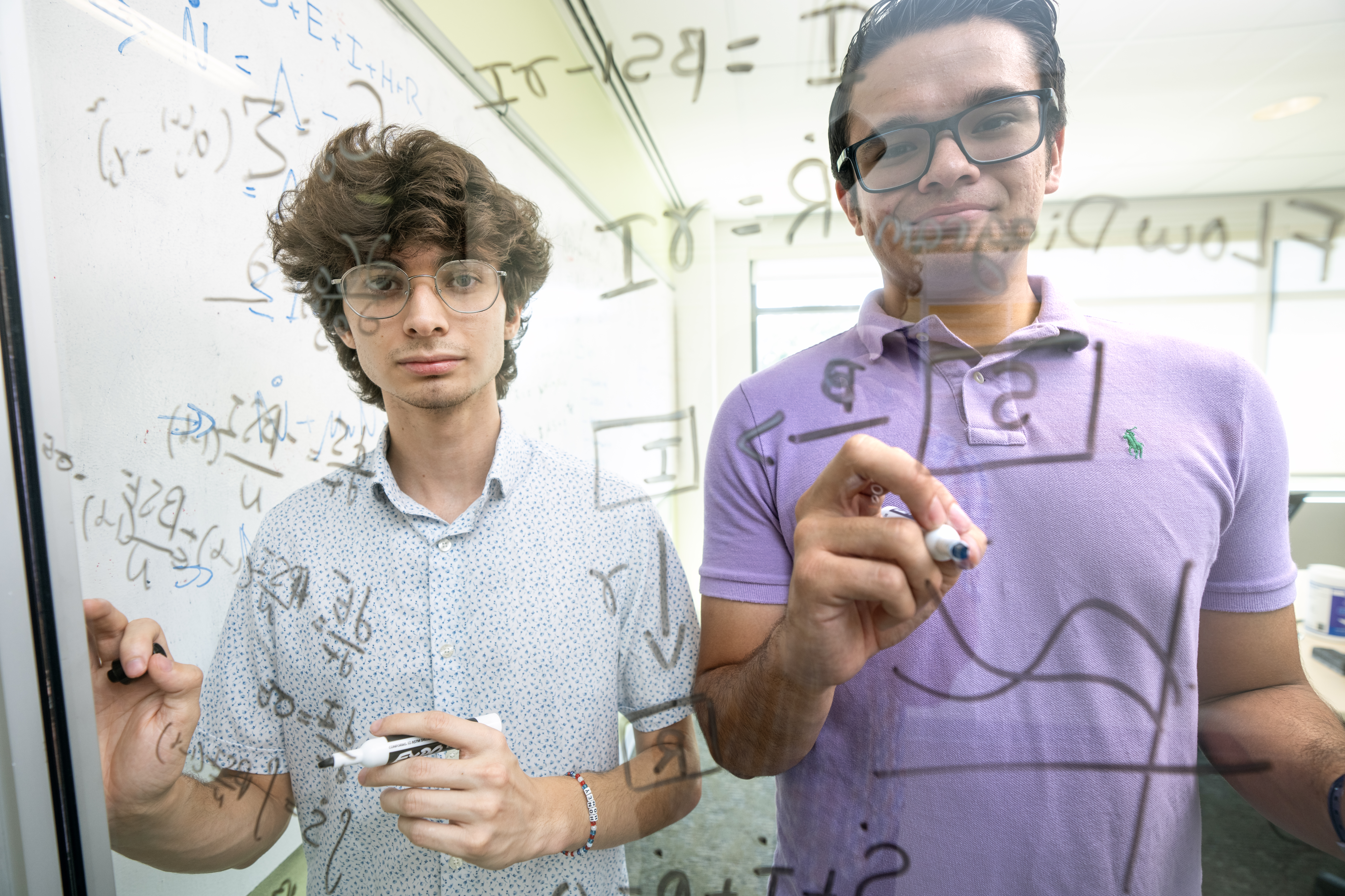 Padhu Seshaiyer, PhD, and graduate student Alonso Ogueda mentor students Adan Baca (pictured on left) and Diego Gonzales working on mathematical modeling, analysis and simulation of patient detox journey with a Society for Industrial and Applied Mathematics (SIAM) grant. Photo by Evan Cantwell/Creative Services/George Mason University